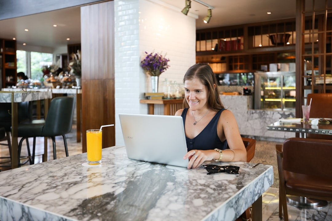 Young woman blogger writing on a laptop and smiling